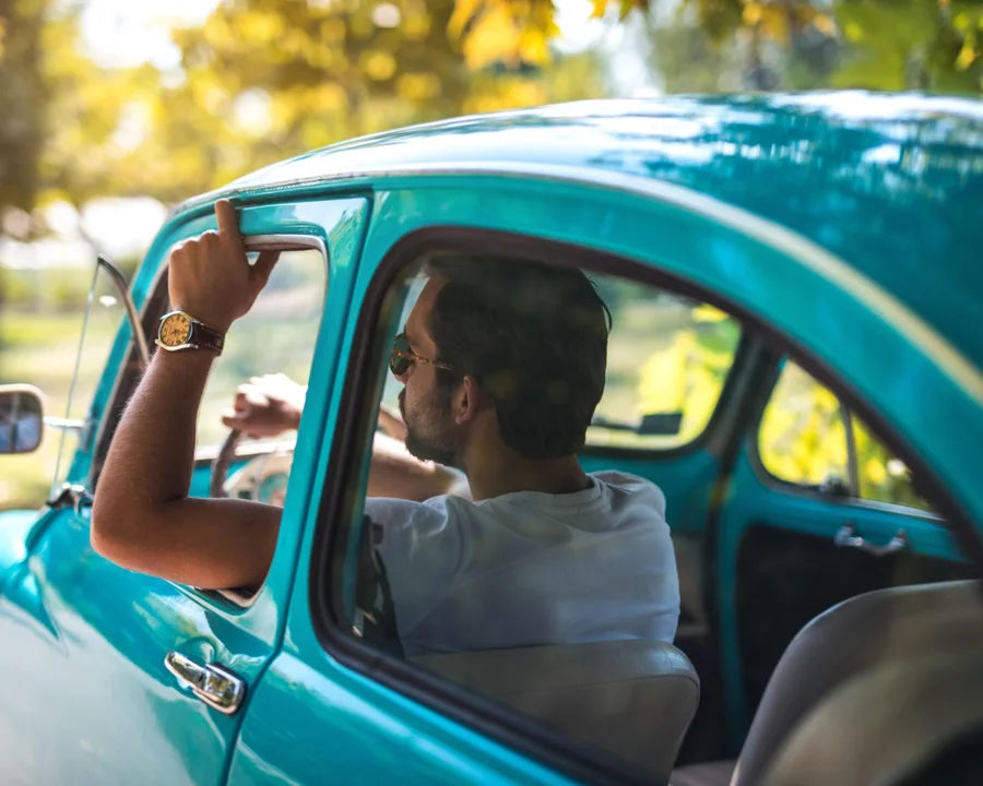 Photo originale d’un homme au volant d’une voiture turquoise