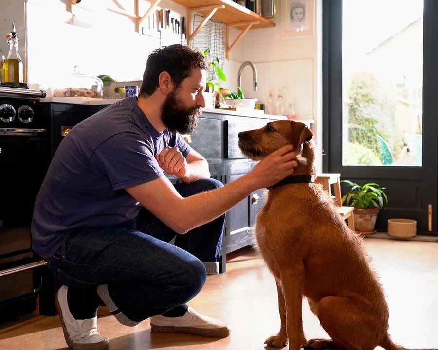 Photo originale d’un homme et de son chien dans une cuisine